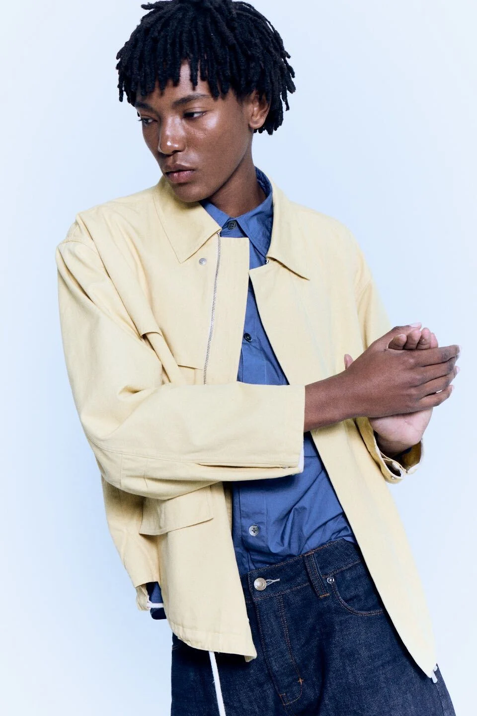 A man in a yellow jacket and denim shirt, ready to film his clothes