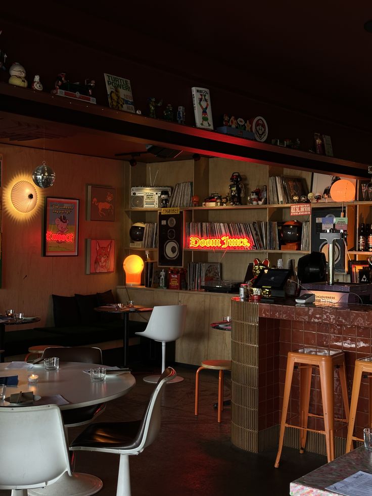 A warm, dimly-lit Melbourne cafe with neon signs and records